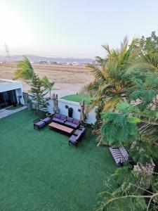 an aerial view of a lawn with chairs and a golf course at G R A N D C H A L E T in Salalah