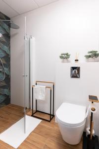 een witte badkamer met een toilet en een douche bij Apartamenty Wola Tower in Warschau