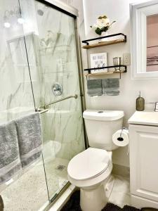 a bathroom with a toilet and a glass shower at Intimate Casita Mia minutes away from Airport, Calle 8, Brickell, Coral Gables, The beach and more! in Miami