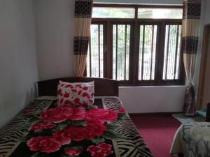 een slaapkamer met een bed met een bos bloemen erop bij La Rose Home Stay in Nuwara Eliya