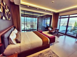 a bedroom with a large bed in a room with large windows at G R A N D C H A L E T in Salalah