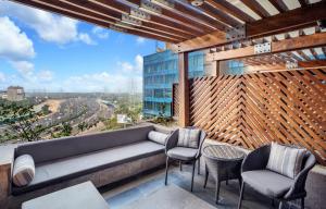 a rooftop patio with a couch and two chairs at The Leela Ambience Gurugram Hotel & Residences in Gurgaon