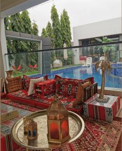 a living room with red furniture and a swimming pool at G R A N D C H A L E T in Salalah