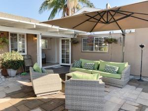 a patio with two couches and an umbrella at Hot Tub . Near Freeway . Quick 2 Theme Parks/Beach in Huntington Beach