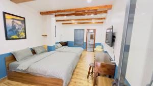 a bedroom with a large bed and a desk at Dalat Family Hostel in Da Lat +26 photos