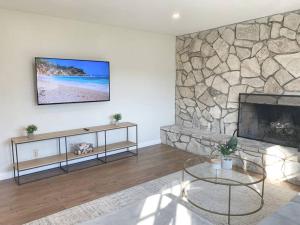 a living room with a fireplace and a tv on a wall at Hot Tub . Near Freeway . Quick 2 Theme Parks/Beach in Huntington Beach
