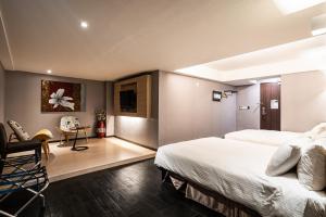 a hotel room with two beds and a desk at Global Traveler Hotel in Kaohsiung