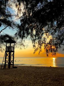 una torre di bagnino su una spiaggia al tramonto di Sel de Mer Apartment Grand World Phu Quoc a Phu Quoc