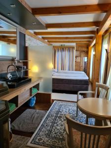 ein Schlafzimmer mit Bett, Tisch und Waschbecken in der Unterkunft Haslaustube in Schwarzenbach an der Pielach