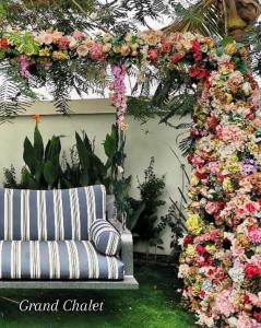 a floral arch with a sofa in a garden at G R A N D C H A L E T in Salalah