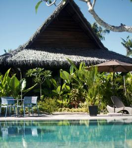 uma piscina num resort com cadeiras e um guarda-sol em Kaimana Resort Siargao em General Luna