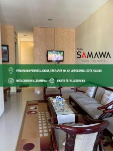 uma sala de estar com um sofá e uma mesa em Villa Samawa em Malang