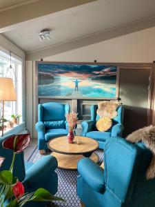 Säter的住宿－Säters Stadshotell，客厅配有蓝色的椅子和桌子