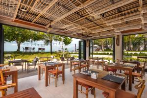 ein Restaurant mit Tischen und Stühlen und Meerblick in der Unterkunft U Samui in Bangrak Beach