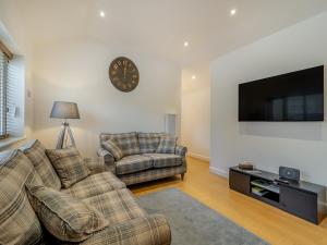 a living room with two couches and a flat screen tv at The Cottage in Langsett
