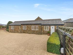 a brick house with a fence in front of it at The Cottage in Langsett