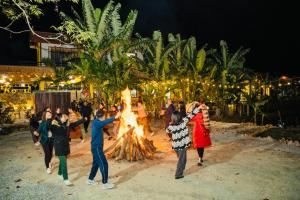 a group of people dancing around a fire at Ninh Binh Royal Homestay in Ninh Binh +123 photos