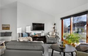 ein Wohnzimmer mit einem Sofa und einem TV in der Unterkunft Beautiful Home In lbk With Wifi in Ålbæk