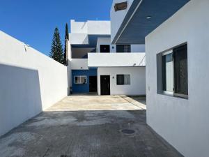 a large white building with a blue door at Departamentos San Pedro in San Pedro Tesistán