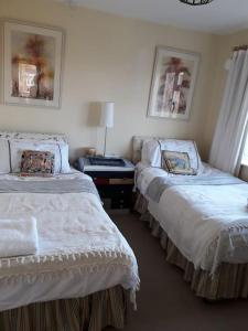 een slaapkamer met 2 bedden en een tafel met een lamp bij Escape to the Country in wonderful Worcestershire in Ombersley