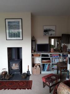 a living room with a fireplace and a tv at Escape to the Country in wonderful Worcestershire in Ombersley