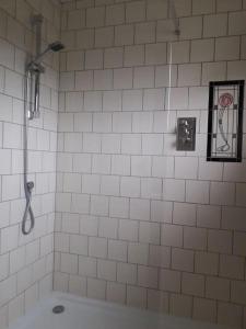 a white tiled bathroom with a shower and a picture at Escape to the Country in wonderful Worcestershire in Ombersley