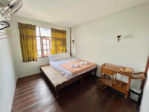 a small room with a bed and a wooden table at DonMueang Boutique House DonMueang Airport in Bangkok