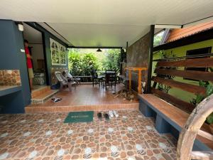 a room with a bench and a table and chairs at Garden Bungalow Resort in Thai Muang