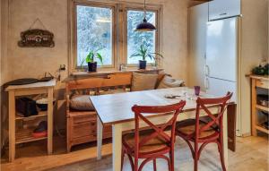 een keuken met een tafel en stoelen en een koelkast bij Pet Friendly Home In Frgelanda With Kitchen in Färgelanda