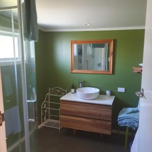 y baño con lavabo y espejo. en Daydream house, Sunrise, sunset views across lake en Rotorua