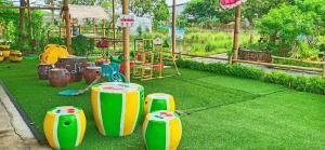 einen Park mit einem Spielplatz mit grünem Kunstrasen in der Unterkunft Ban Ing Suan in Samutprakarn