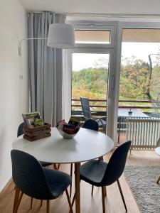 una mesa y sillas blancas con vistas a un balcón en Seeblickapp. „Eure Auszeit“ en Goslar