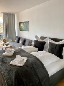a bedroom with a large bed and a couch at Seeblickapp. „Eure Auszeit“ in Goslar