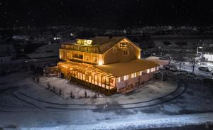 dom ze światłami na górze w śniegu w obiekcie Hotel Kunst w mieście Krško