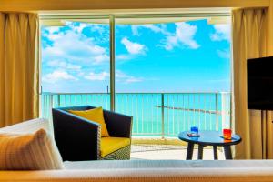 Cette chambre dispose d'une grande fenêtre offrant une vue sur l'océan. dans l'établissement Laguna Garden Hotel, à Ginowan
