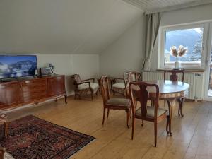 ein Wohnzimmer mit einem Tisch und Stühlen sowie einem TV in der Unterkunft sechzehnerhaus in Mariazell