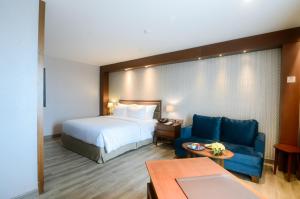 Un pat sau paturi într-o cameră la The Excelton Hotel