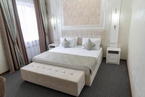 a bedroom with a large bed and a couch at Dora Hotel in Shymkent
