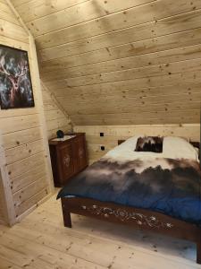 a bedroom with a bed in a wooden cabin at beskid house in Spytkowice