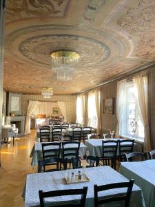 a dining room with tables and chairs and a ceiling at Säters Stadshotell in Säter