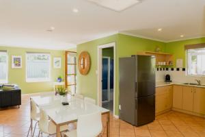 a kitchen with a white table and a refrigerator at Albany Harbourside Apartments And Houses in Albany