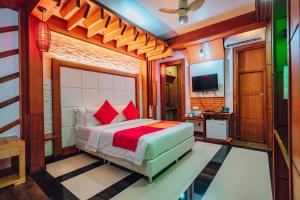 1 dormitorio con 1 cama con almohadas rojas en Millennium Island Residence, en Fuvahmulah