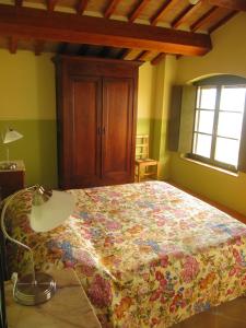 a bedroom with a bed and a lamp and a window at Agriturismo Serracanina in Cagli