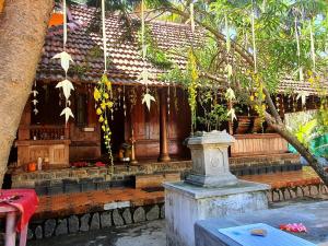 un bâtiment avec une table devant lui dans l'établissement Thriphala Ayurveda Yogashram, à Trivandrum