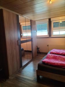 1 dormitorio con cama y espejo en Ferienwohnung Naturblick, en Schönhagen