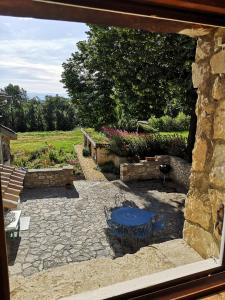 un patio de piedra con mesa azul y sillas en Chez Nathalie et Raphaël, en Grane