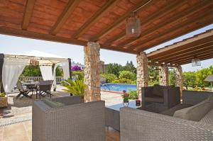 patio con sedie, tavolo e piscina di Ideal Property Mallorca - Can Rius a Muro