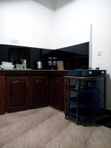 a kitchen with wooden cabinets and a counter top at River Valley in Weligama