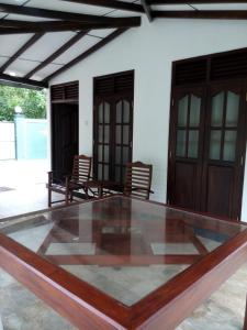 a patio with two chairs and a table and doors at River Valley in Weligama