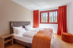 una camera con letto e finestra con tende rosse di HIDDENSEE I mit Ostseeblick Haus Fore a Lohme